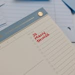 A planner with 'So Many Things' written, surrounded by loose notes.